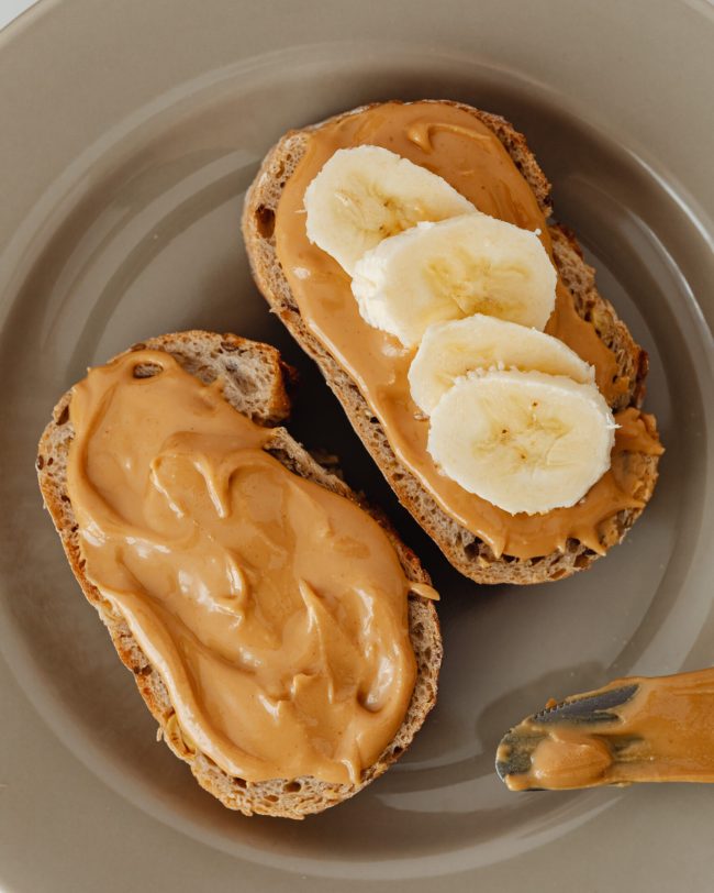 twee boterhammen met pindakaas en banaan